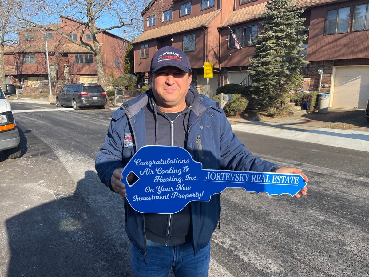 The owner of Air Cooling & Heating, Inc. with the keys to a new investment property